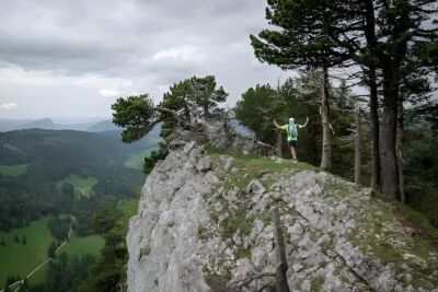 Un corredor de trail en cresta del Jura suizo con paisaje panorámico
