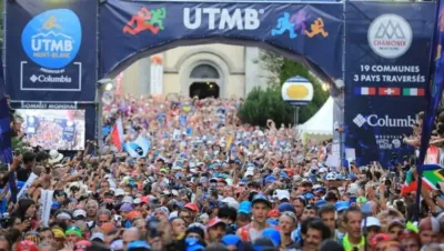 Salida del HOKA UTMB Mont-Blanc desde Chamonix con miles de corredores en la Place Triangle de l'Amitié