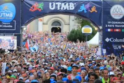 Salida del HOKA UTMB Mont-Blanc desde Chamonix con miles de corredores en la Place Triangle de l'Amitié
