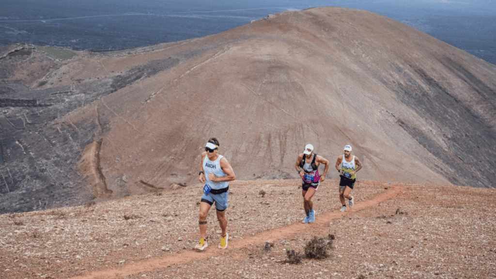 Corredores de trail running atravesando paisaje volcánico en Lanzarote durante una carrera