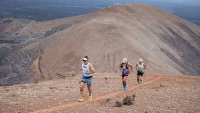 Corredores de trail running atravesando paisaje volcánico en Lanzarote durante una carrera