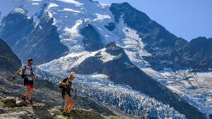 Pareja en PTL UTMB 2026 en terreno técnico de alta montaña en la vuelta al macizo del Mont Blanc